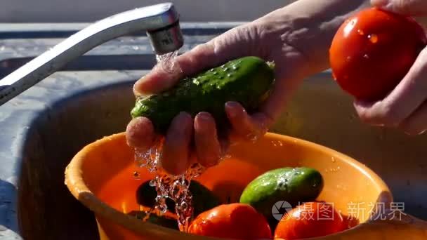 手洗黄瓜和西红柿在水龙头下