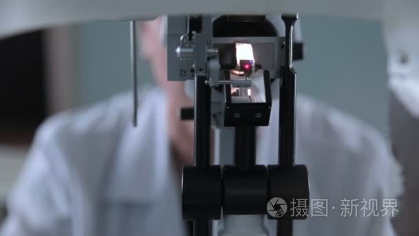 眼科医疗器械的视力检查。变得面目全非的医生与病人眼测试工作