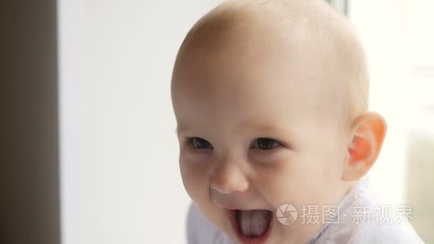 Portrait of happy smiling baby near window at home. Happy child.