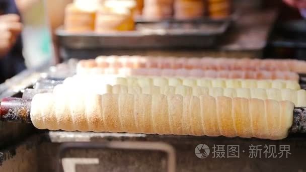 在布拉格市场在户外的街头食品。制作传统的捷克烘焙产品 trdelnik 的过程