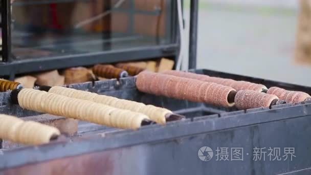 在布拉格市场在户外的街头食品。制作传统的捷克烘焙产品 trdelnik 的过程