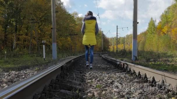 那个女孩在铁轨上走在秋天视频