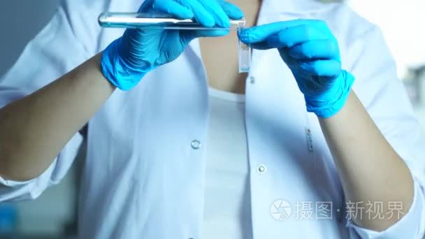 科学家女人液体涌入在实验室或医院的医疗仪器。样品分析分光光度计试管灌装，关闭