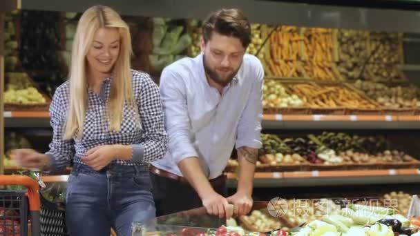 Couple choose bell peppers at the supermarket