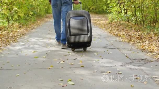 男人带着手提箱走在人行道上视频