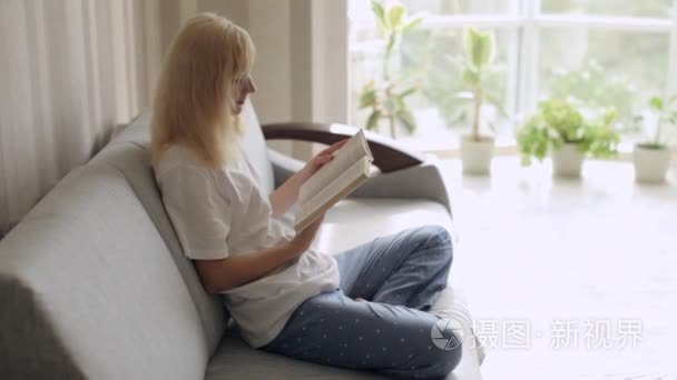 穿着睡衣坐在沙发上看书的女人视频