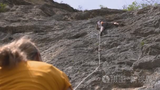 一个摇滚男登山者爬上岩石视频