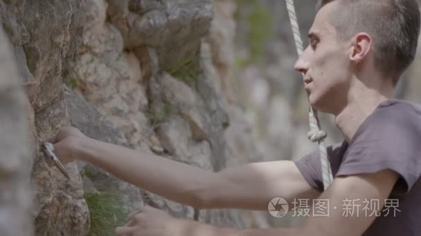 一个摇滚男登山者爬上岩石视频