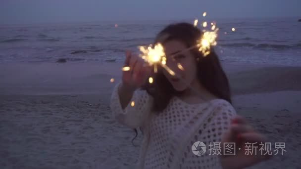 女人玩烟火在海边晚上视频