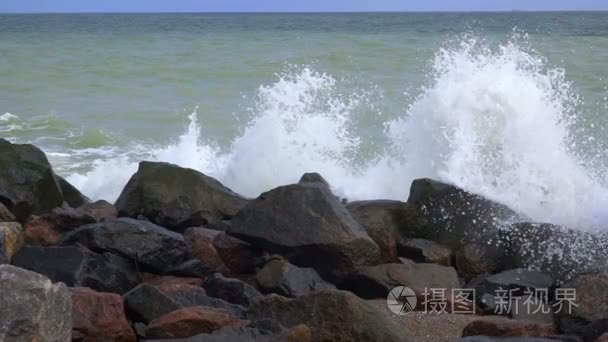 多岩石的海岸和飞溅的浪花。慢动作