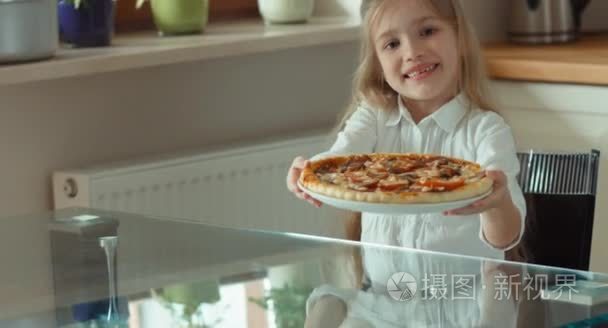 女孩拿着一个大的美丽比萨饼。女孩提供比萨饼查看器。一名小孩手握出去吃比萨给朋友