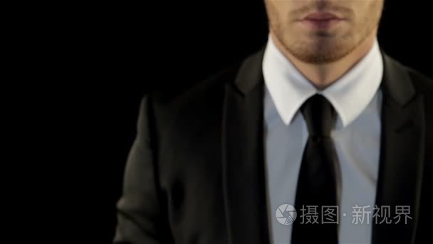 男子黑色套件中的显示他的拳头