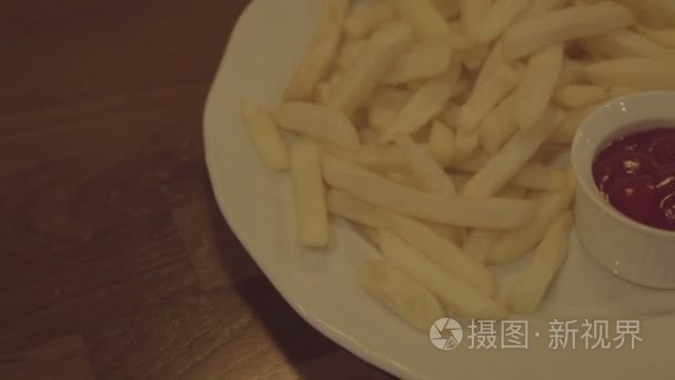 在盘子里番茄酱的薯条。快餐食品酱在桌子上