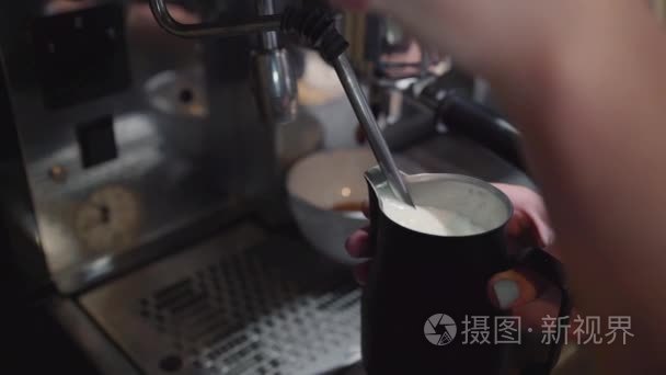 咖啡师使两杯咖啡牛奶