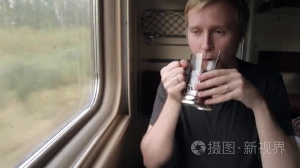 坐在火车的窗户上喝茶的男人视频