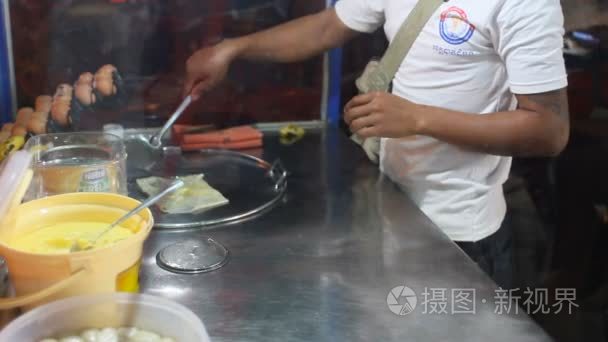 泰国，曼谷男人做饭煎饼与香蕉和甘甜的乳汁，在亚洲的传统甜点。小小的街边咖啡馆