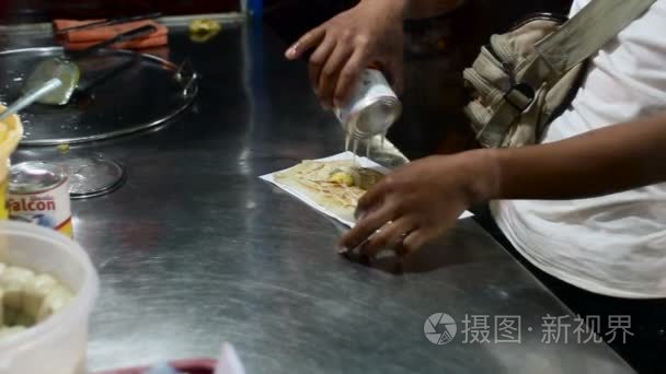 泰国，曼谷-男人做饭煎饼与香蕉和甘甜的乳汁，在亚洲的传统甜点。小小的街边咖啡馆