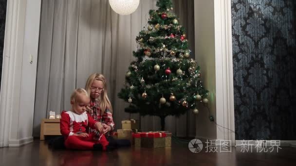 小男孩和女孩开放在圣诞节礼物视频
