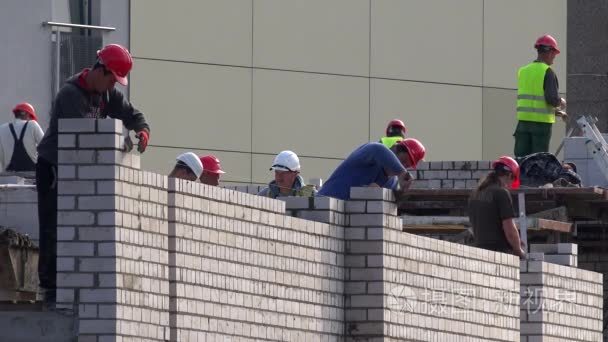 专业工人队伍铺设的白砖房子墙视频