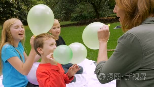 三个孩子和一位母亲让气球飞走了slomo 掌上电脑