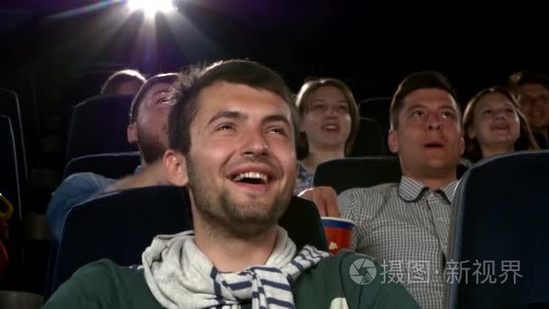 年轻男子在电影院看电影︰ 喜剧。关闭
