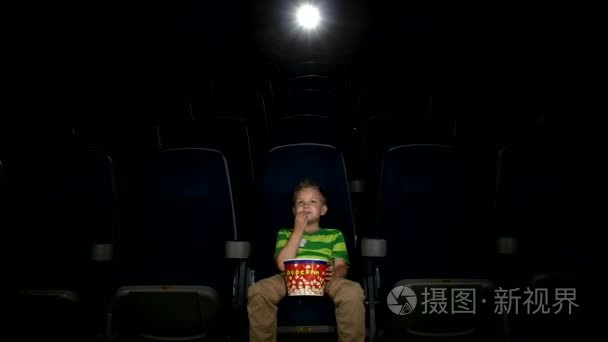 微笑在电影院中的小男孩看电影