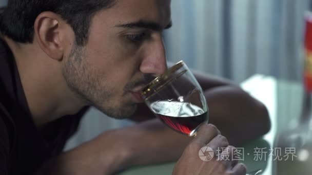 配置文件的醉酒男子一边紧张地喝一杯酒