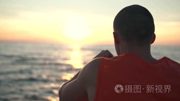 英俊的男人在海滩日落时分拳击视频