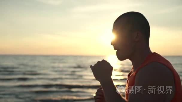 勇敢的人在海边日落时分拳击视频