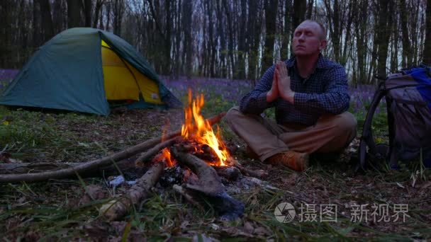 4 k.成年男子在靠近篝火和帐篷的木头沉思默想