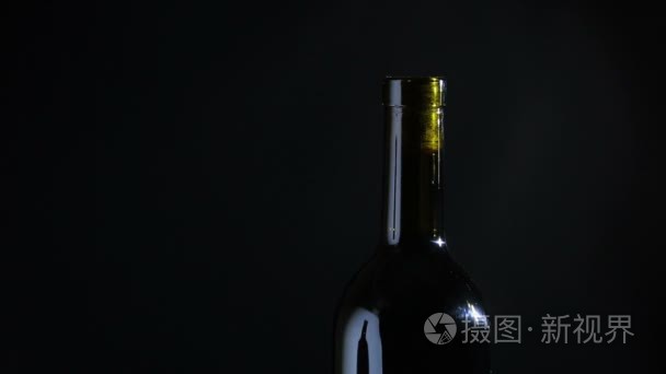 手用开瓶器打开一瓶酒的人。黑色背景