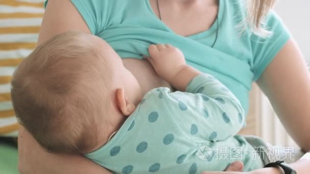 母亲喂她婴儿母乳牛奶