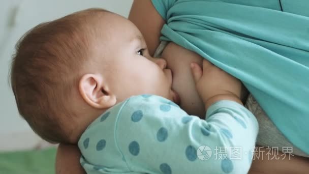 母亲喂她婴儿母乳牛奶