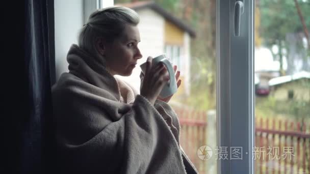 孤独的抑郁症的妇女坐在窗台上视频