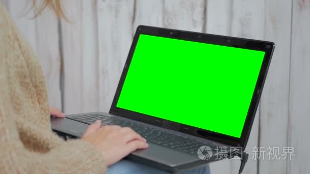 女人用绿屏的笔记本电脑视频