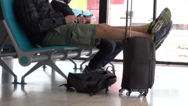 旅行者在他的行李上休息他的脚
