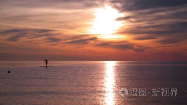 在日落时的冲浪板上的男人视频