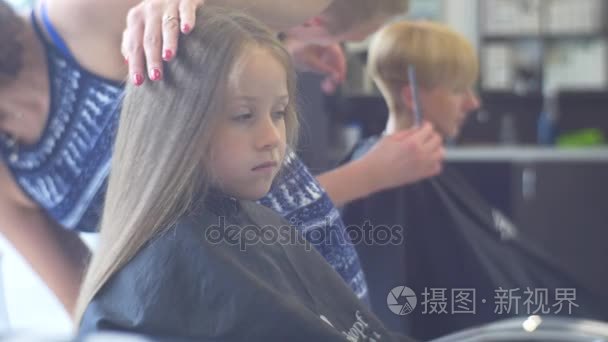 开学那天在沙龙设计师制作发型为客户小女孩十几岁男孩理发师梳金发毛其他设计师正在理发