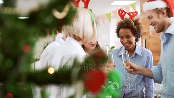 快乐的同事上升他们的眼镜换面包办公室方模糊圣诞树上正面慢动作视频