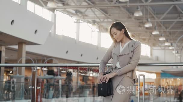 一个十几岁的年轻游客女人来访的商城购物使用她的智能手机设备和微笑的画像。女商人，在机场