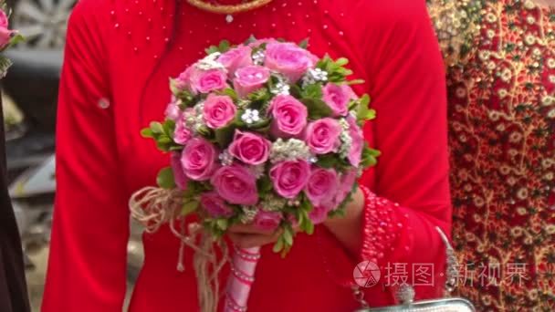 特写穿红衣服的女孩举行婚礼粉红玫瑰花束