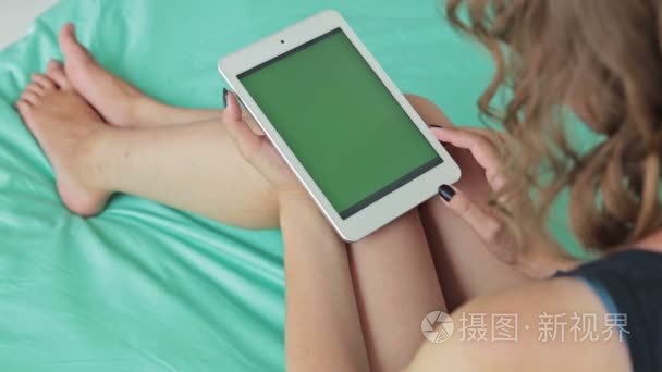 女人看着绿屏平板电脑视频