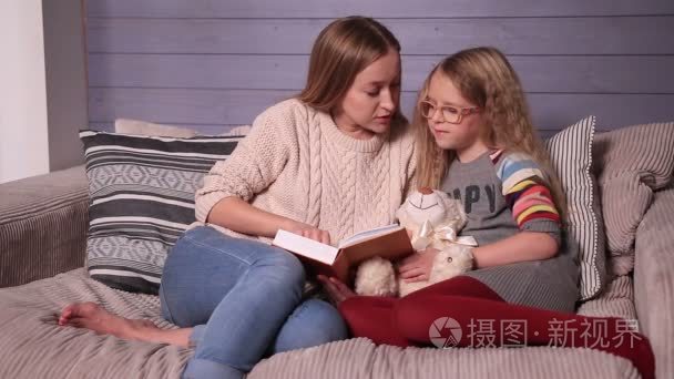 母亲和女儿一起阅读故事在家里视频