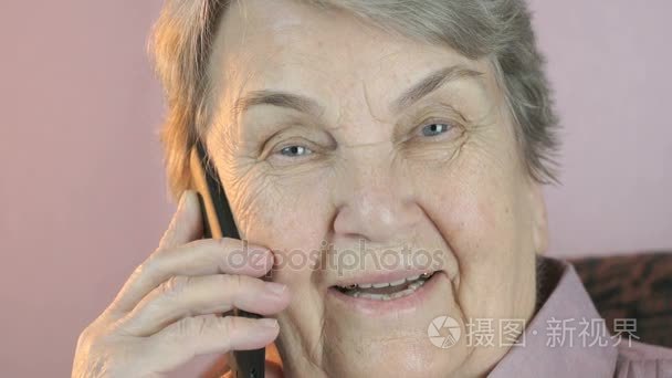 奶奶笑着在移动电话上的会谈视频