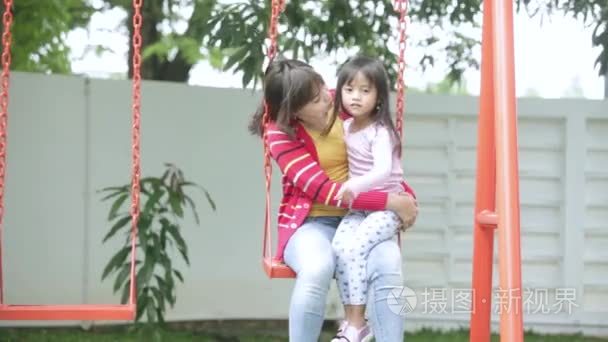 亚洲妈妈亲吻她的女儿在秋千上视频
