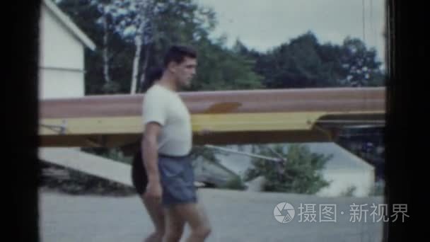 运动型的男人们手持独木舟船