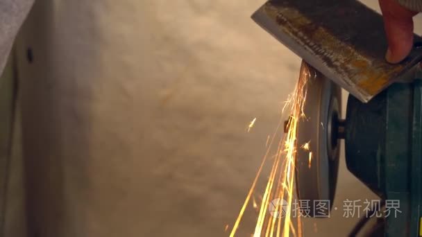 金属工人在工厂磨铁斧火花视频