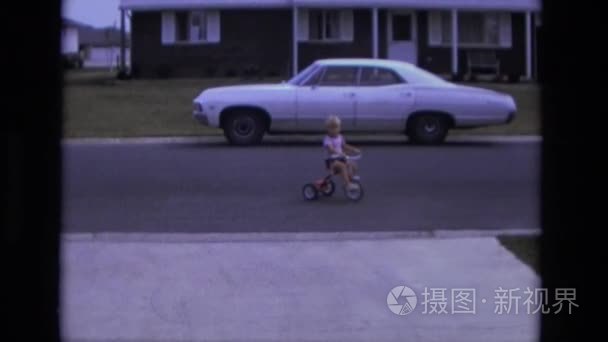 附近道路上骑三轮车的男孩视频