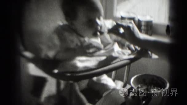 女人喂养幼儿在高脚椅视频
