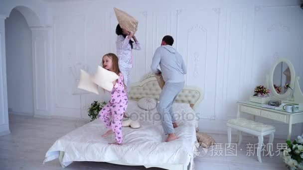 家族争斗枕头，跳床一起在睡衣上的肖像